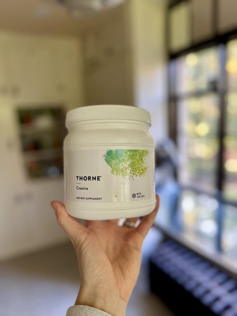 Thorne Creatine Hand Holding Container in kitchen