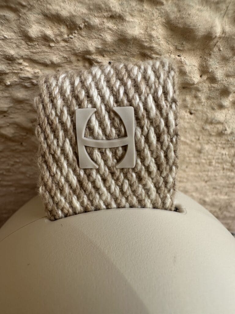 Hatch Go portable baby sound machine hand eco-friendly materials close up of Hatch logo and material fabric clip