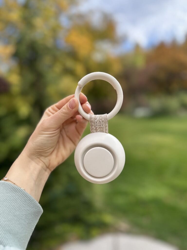 Hand holding Hatch Go Portable Baby Sound Machine hanging