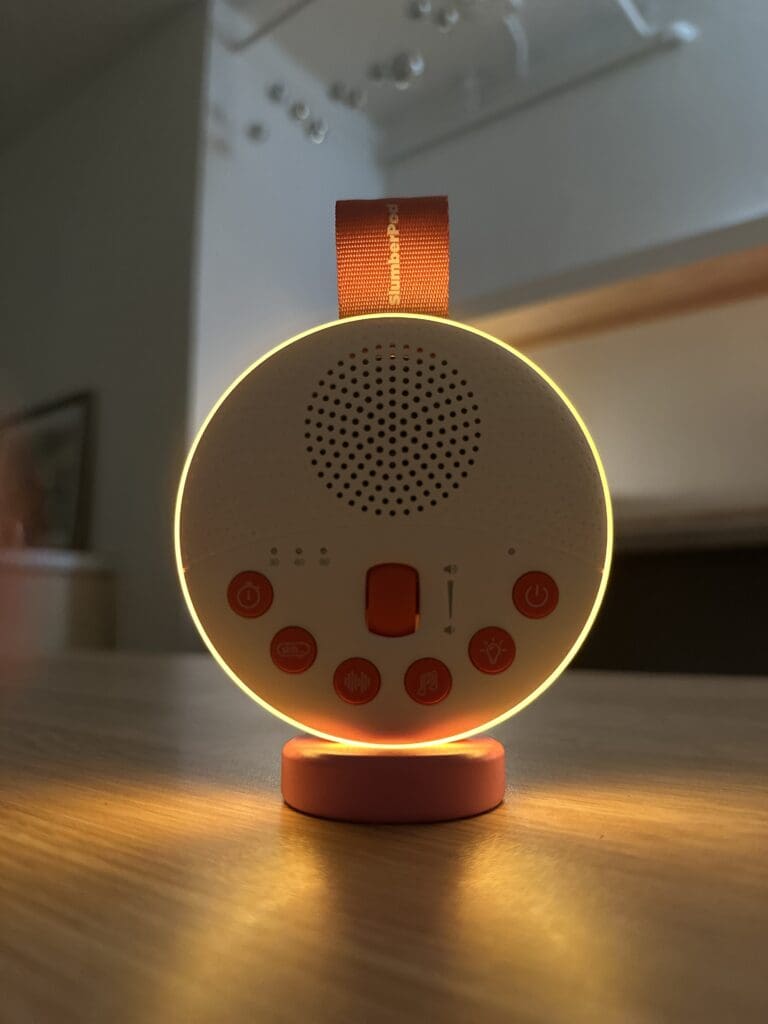 SlumberPod SlumberCalm portable baby sound machine close up of night light sitting on desk front view