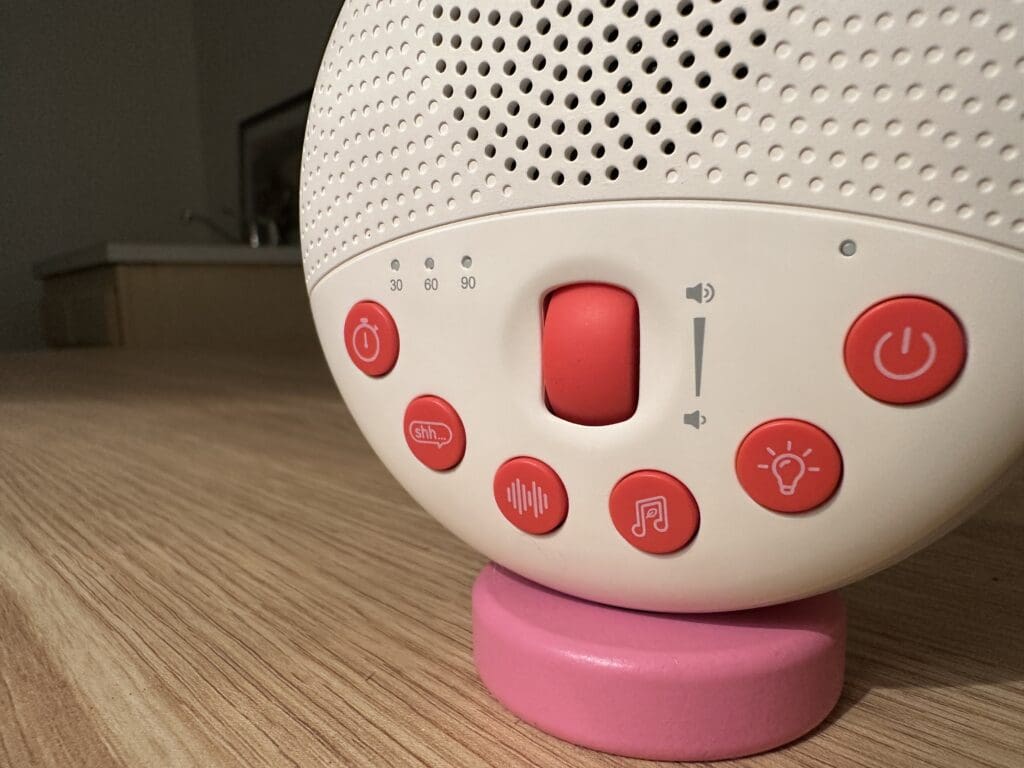 SlumberPod SlumberCalm portable baby sound machine close up of buttons including volume roller, shhh, whitenoise, light, music and timer and power)