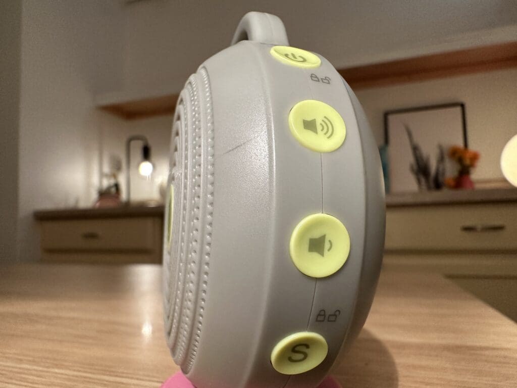 Yogasleep hushh portable baby sound machine up close side view of buttons sitting on desk