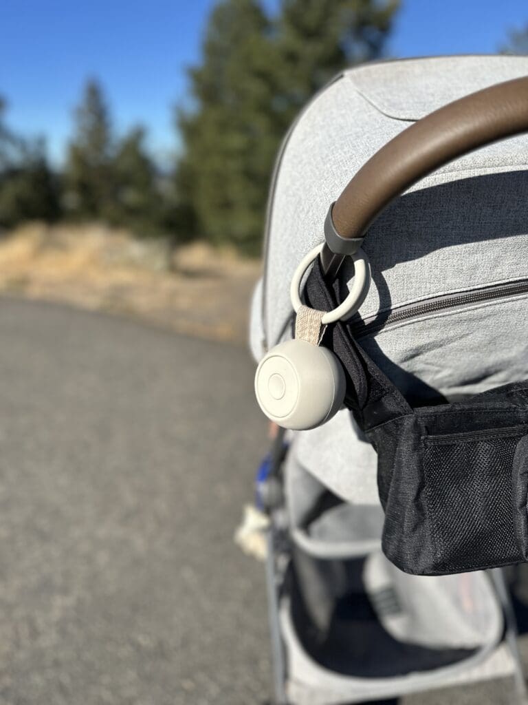 Hatch Go Portable Baby Sound Machine Hanging On Stroller On Bright Sunny Day