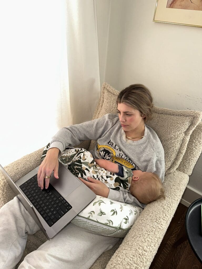 Mother and Baby in nursing chair, mom working and baby napping on boppy nursing pillow