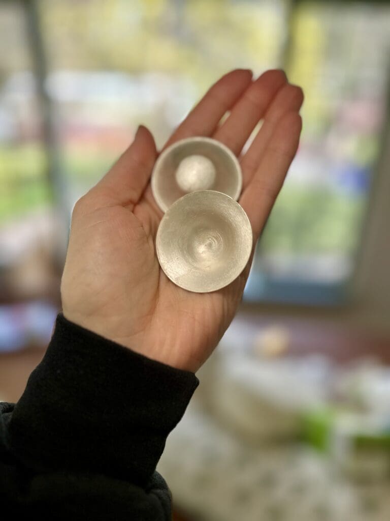 Silverettes Sterling Silver Nipple Covers being held in hand